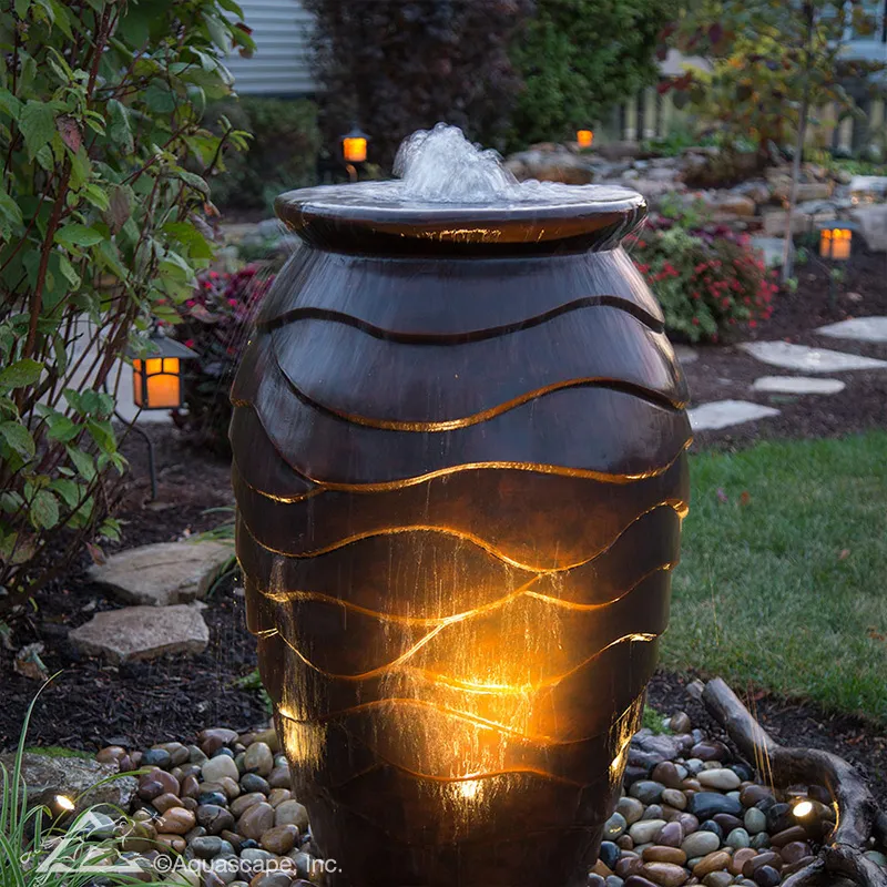 Illuminated scalloped urn fountain at night